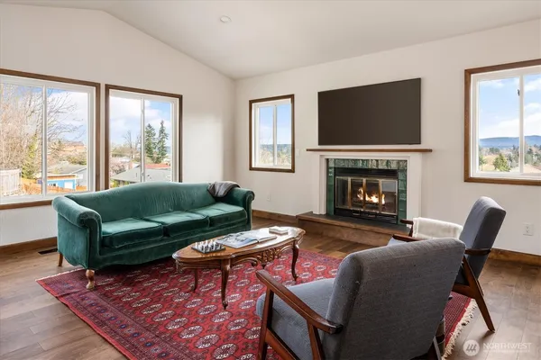 a living room with furniture a flat screen tv and a fireplace