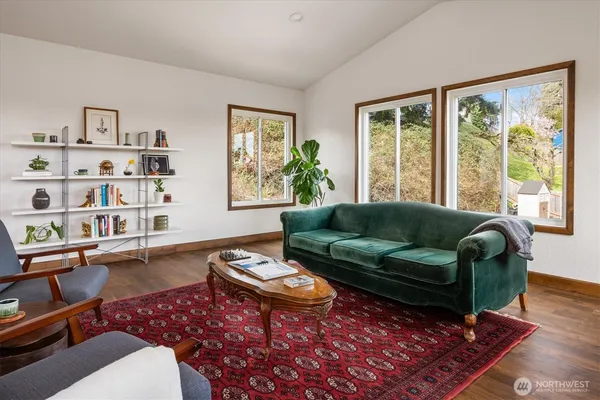a living room with furniture large window and wooden floor