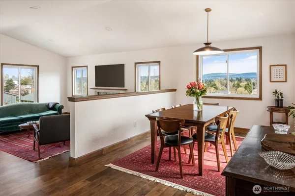 a view of a livingroom and dining room with furniture window and wooden floor