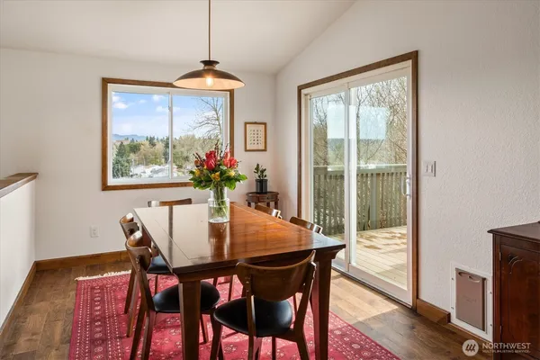 a dining room with furniture window and wooden floor