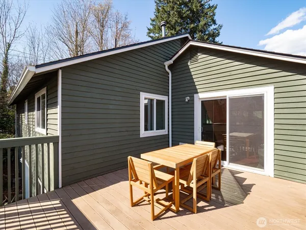 a view of a patio with table and chairs with wooden floor and fence