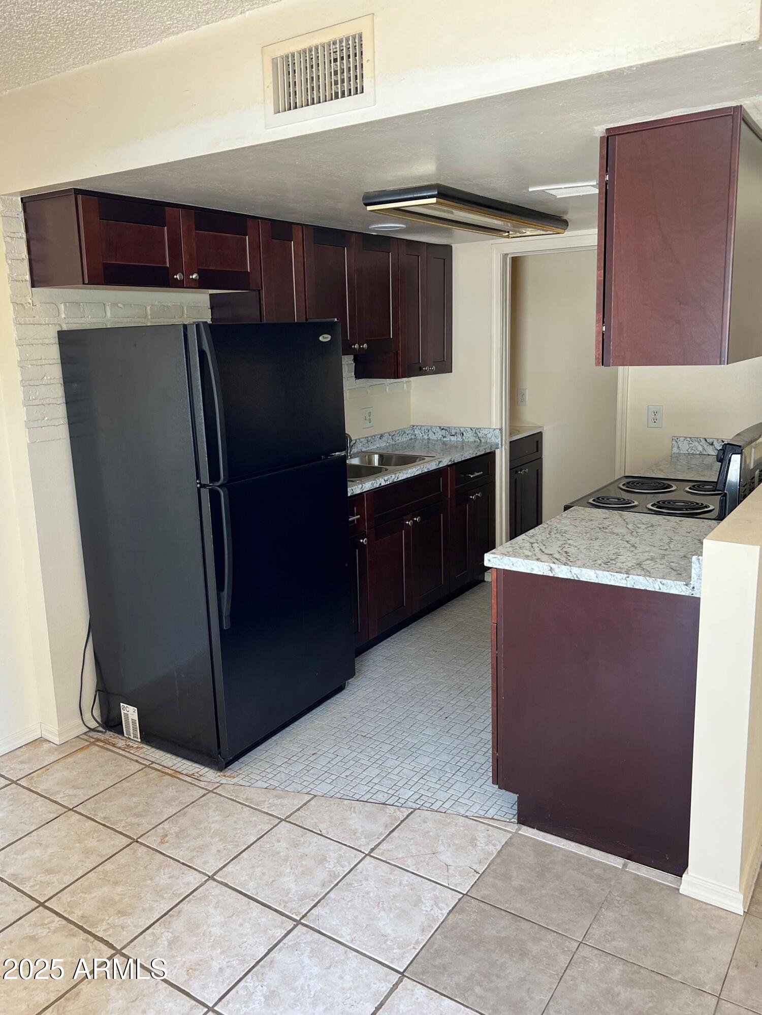 4718 East Portland Street Phoenix, AZ 85008 - Photo 4 of 11 a kitchen with stainless steel appliances granite countertop a refrigerator and a stove