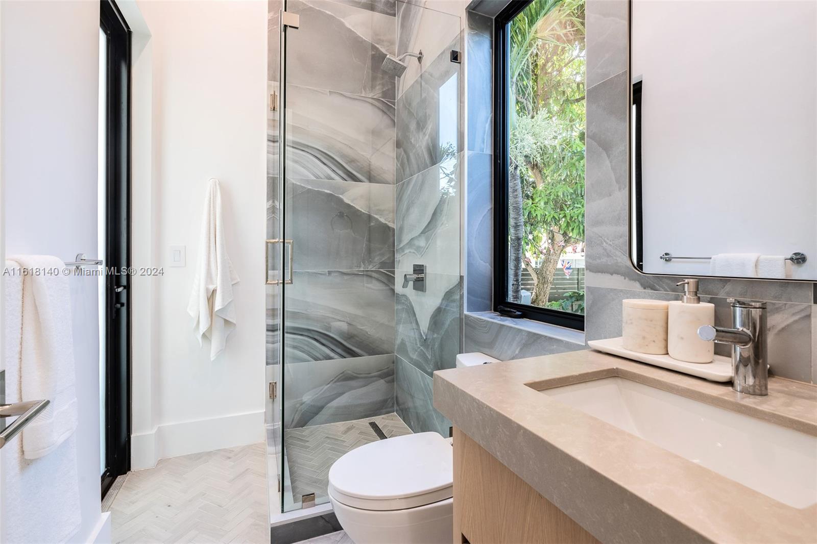 9000 Abbott Avenue Surfside, FL 33154 - Photo 26 of 82 a bathroom with a sink a toilet a mirror and shower