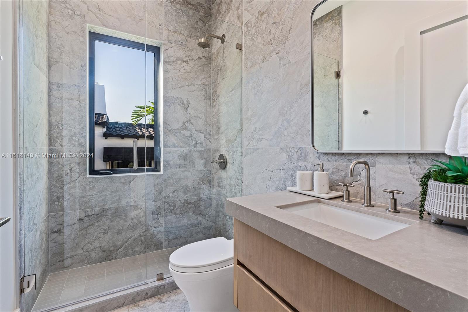 9000 Abbott Avenue Surfside, FL 33154 - Photo 44 of 82 a bathroom with a granite countertop sink a toilet and shower