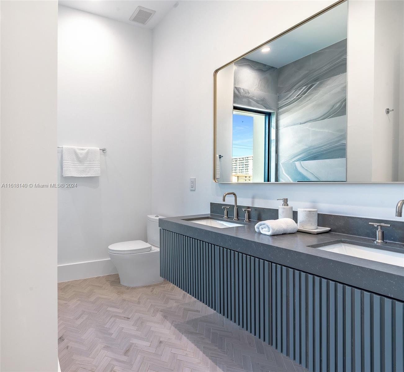 9000 Abbott Avenue Surfside, FL 33154 - Photo 59 of 82 a bathroom with a toilet sink and mirror