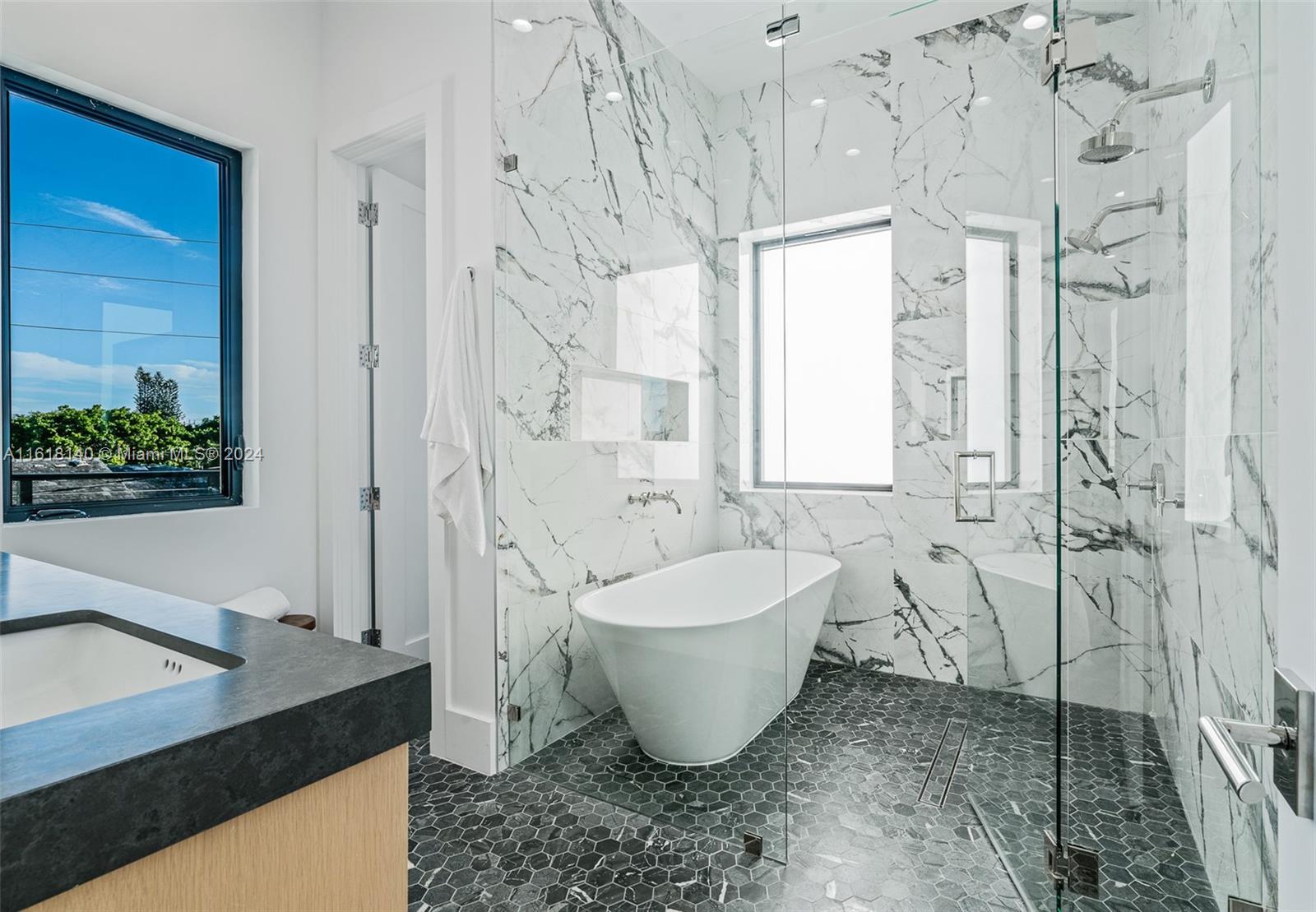 9000 Abbott Avenue Surfside, FL 33154 - Photo 69 of 82 a spacious bathroom with a granite countertop sink a toilet a mirror and shower