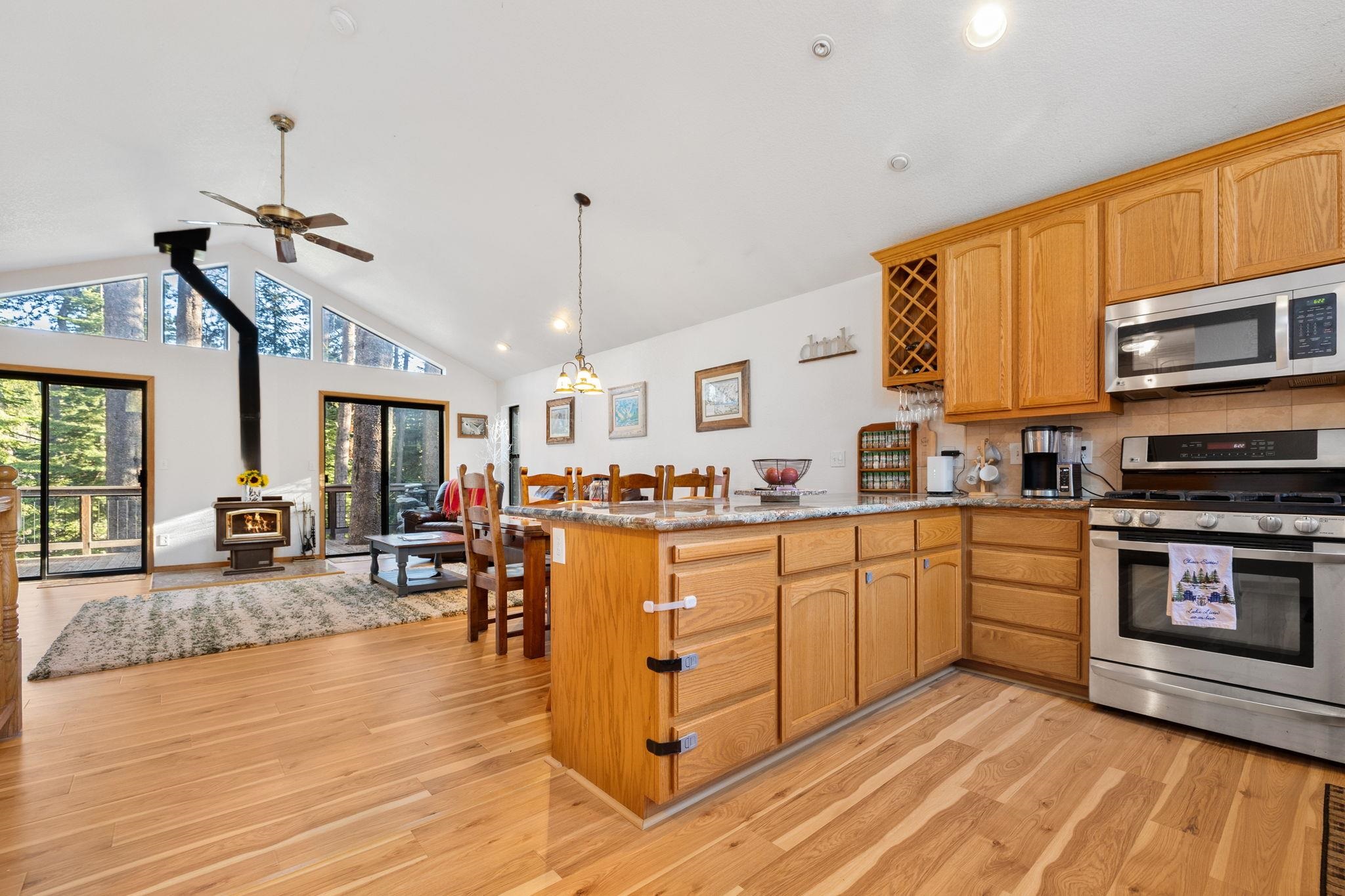 50689 Conifer Drive Soda Springs, CA 95728 - Photo 4 of 28 a kitchen with stainless steel appliances granite countertop a stove top oven a sink a dining table and chairs with wooden floor