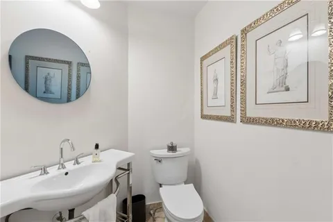 a bathroom with a toilet a sink and mirror