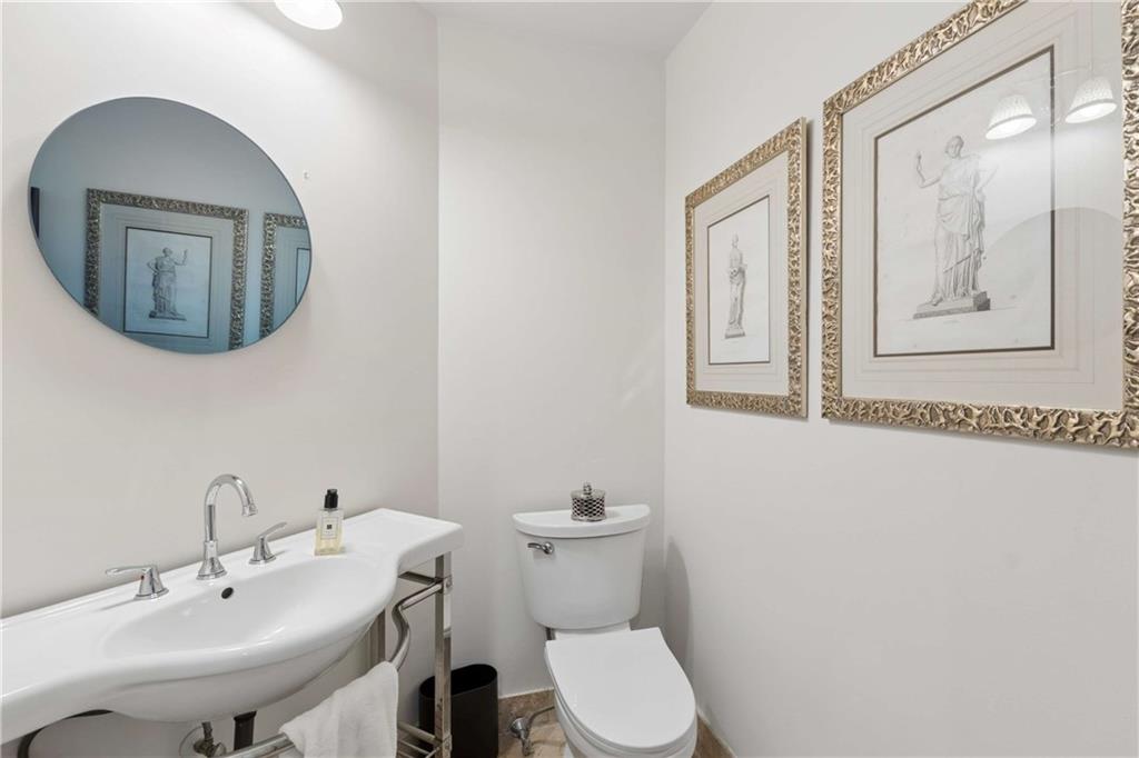 2660 Peachtree Road Northwest, Unit 39D Atlanta, GA 30305 - Photo 21 of 45 a bathroom with a toilet a sink and mirror
