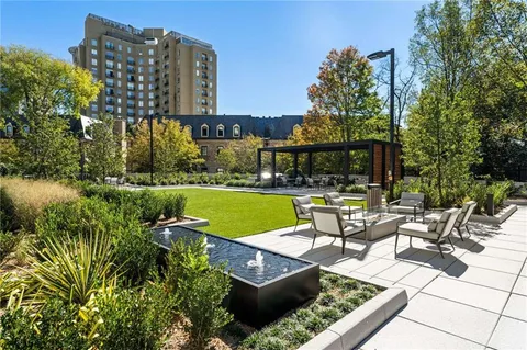a view of swimming pool with outdoor seating and a garden