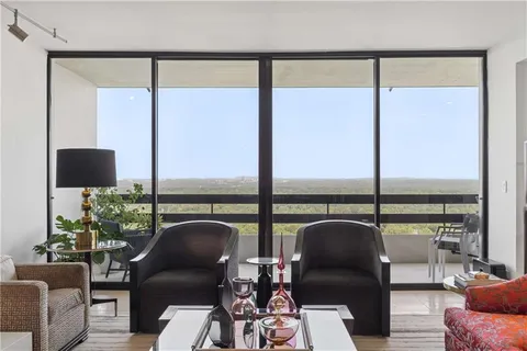 a view of a livingroom with furniture and floor to ceiling window