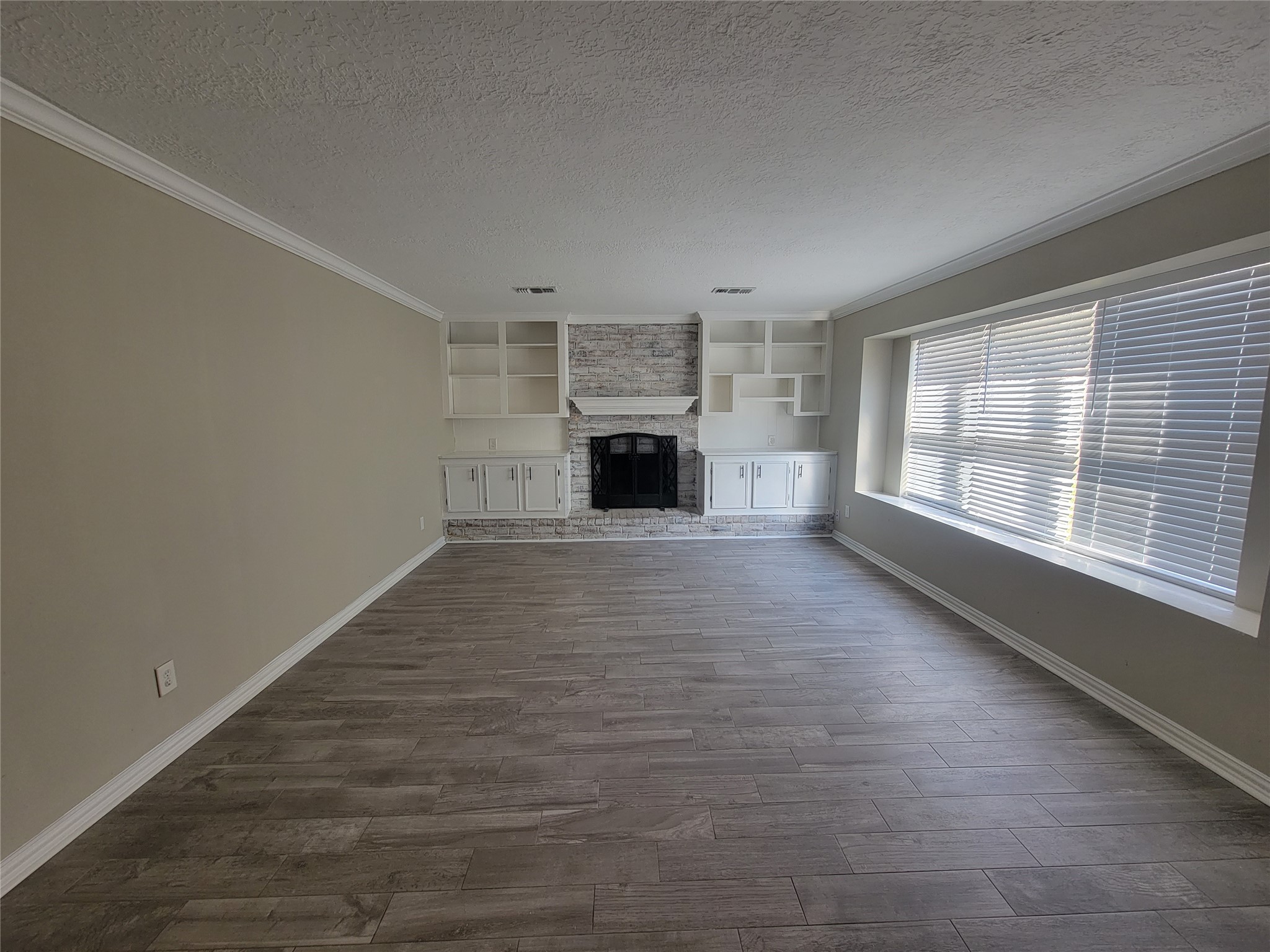 4015 Chapel Square Drive Spring, TX 77388 - Photo 16 of 27 A spacious living room featuring a charming brick fireplace that beautifully enhances the harmonious flooring and wall tones.