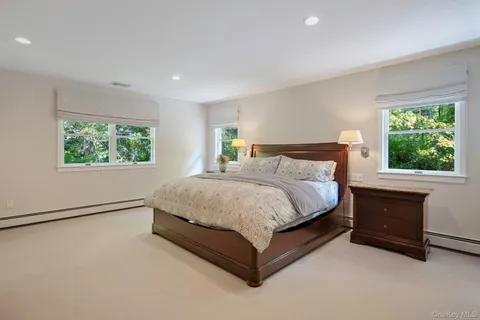 a spacious bathroom with a double vanity sink toilet mirror and bathtub