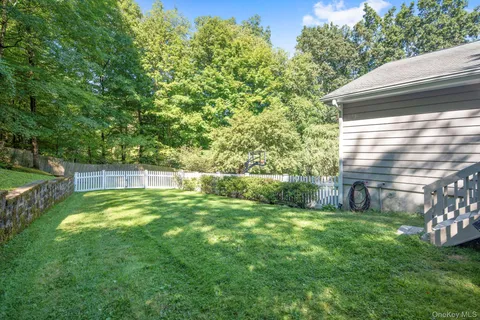 a front view of house with yard and trees in the background