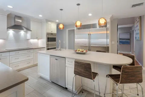 a kitchen with granite countertop a stove a sink and a window