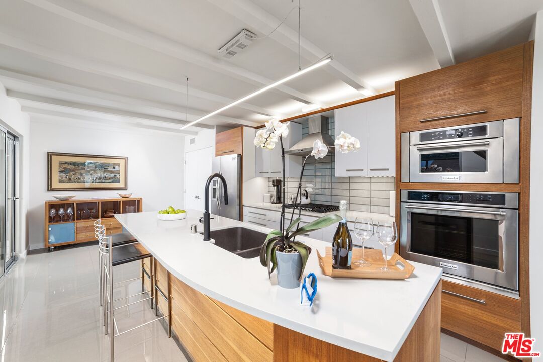 975 East Sunny Dunes Road Palm Springs, CA 92264 - Photo 12 of 40 a kitchen with a sink a stove and chairs