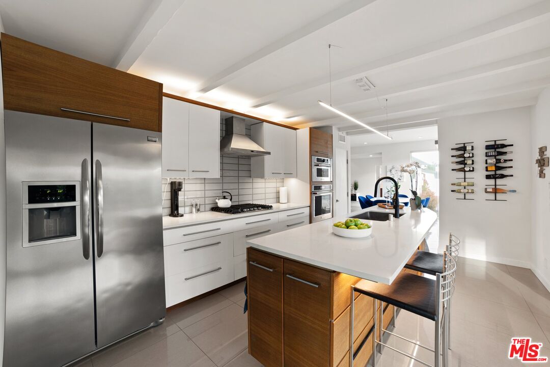 975 East Sunny Dunes Road Palm Springs, CA 92264 - Photo 13 of 40 a kitchen with stainless steel appliances a sink a stove a refrigerator a table and chairs