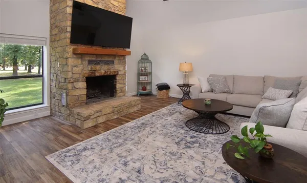a living room with furniture a flat screen tv and a fireplace