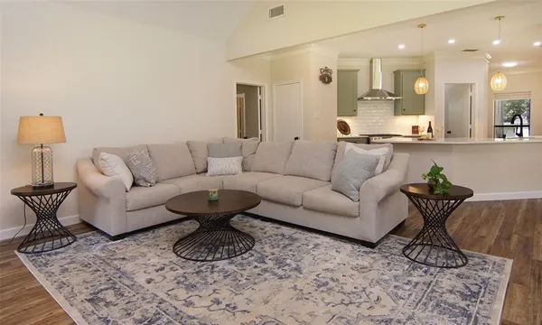 a living room with furniture and a wooden floor