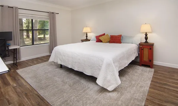 a spacious bedroom with a bed and a lamp