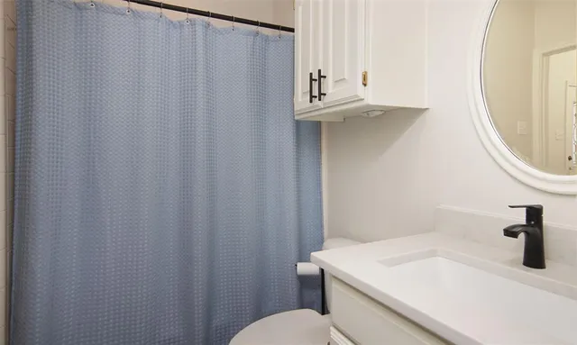 a bathroom with a sink a toilet and a mirror