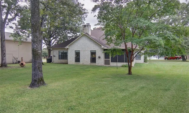 a view of a house with a yard and tree s