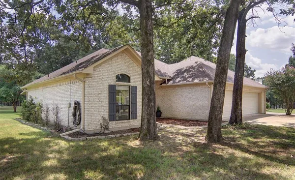 a view of a house with backyard and tree