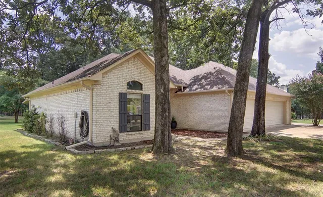 a view of a house with backyard and tree