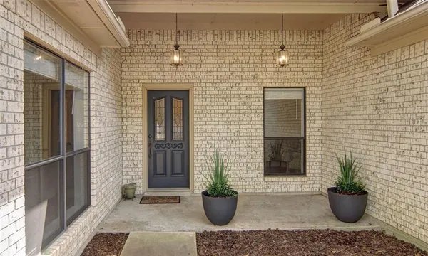 a view of a door of the house with potted plant