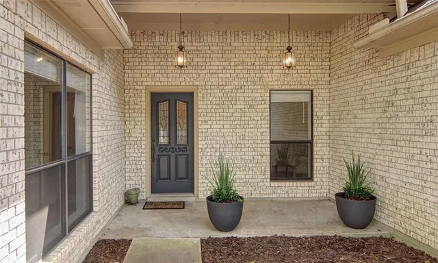 a view of a door of the house with potted plant