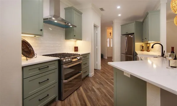 a kitchen with stainless steel appliances a stove and a sink