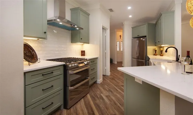 a kitchen with stainless steel appliances a stove and a sink