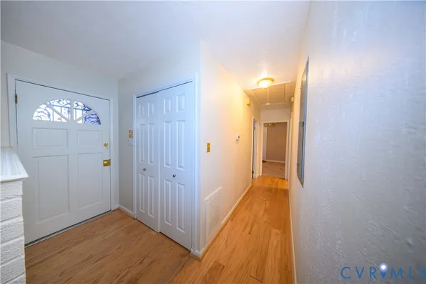 a view of a hallway with wooden floor and closet