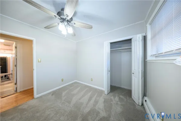wooden floor in an empty room with a chandelier fan