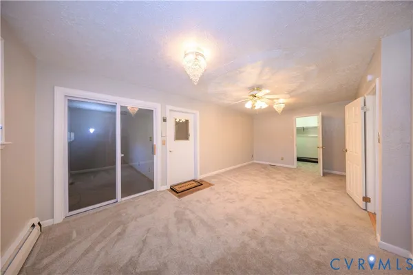 a view of an empty room with a chandelier fan