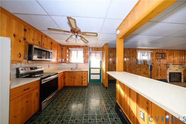 a large kitchen with stainless steel appliances granite countertop a sink and cabinets