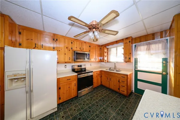 a kitchen with stainless steel appliances granite countertop a refrigerator a stove and a sink with wooden floor