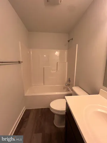 a bathroom with a granite countertop sink toilet a mirror and bathtub