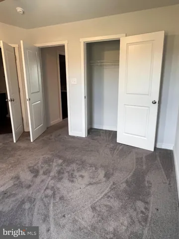an empty room with closet and mirror