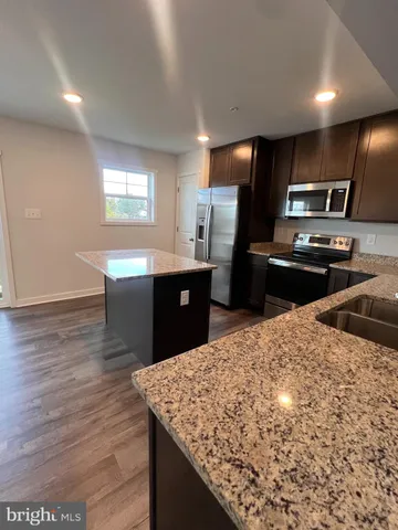 a kitchen with kitchen island sink refrigerator and stove