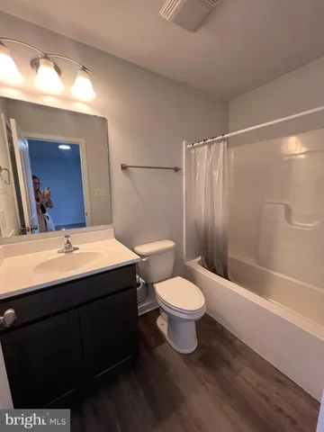 a bathroom with a sink mirror vanity and toilet