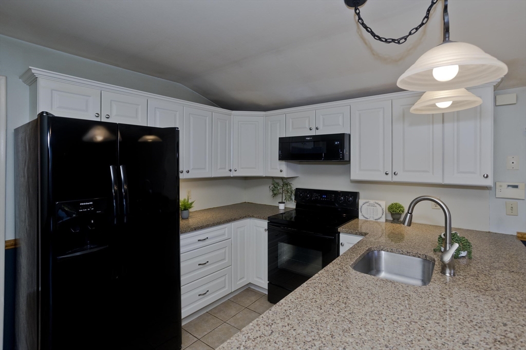 151 Bemis Road Holyoke, MA 01040 - Photo 17 of 42 a kitchen with granite countertop a refrigerator a stove a microwave and sink
