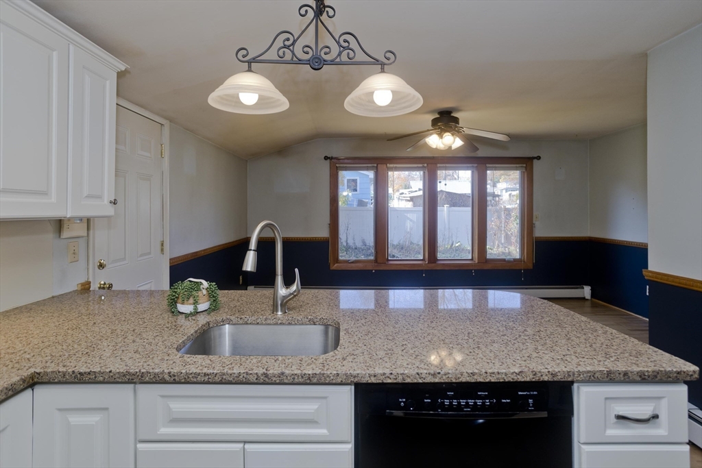 151 Bemis Road Holyoke, MA 01040 - Photo 19 of 42 a kitchen with granite countertop a sink stainless steel appliances and white cabinets