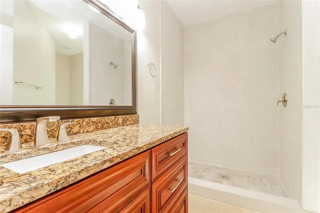 a bathroom with a granite countertop sink and a bathtub