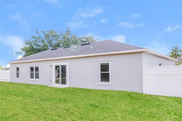 a view of a backyard with plants and large tree