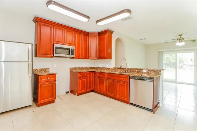 a kitchen with stainless steel appliances granite countertop a stove a sink and a refrigerator