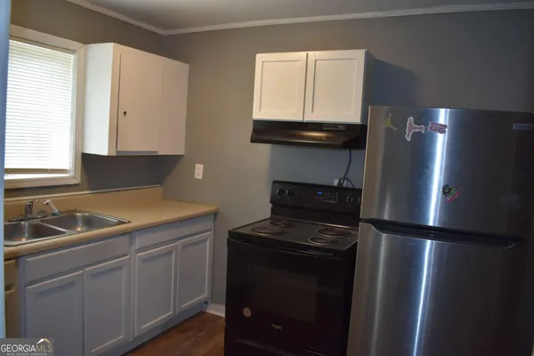 a kitchen with a refrigerator and a sink