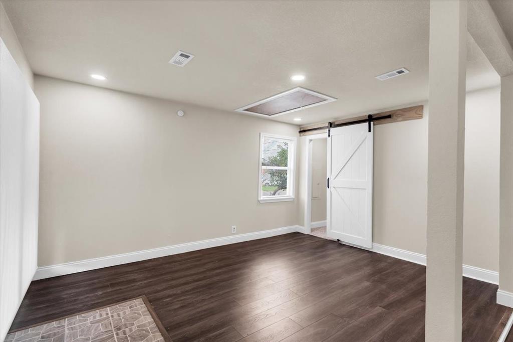1309 Pine Street Bonham, TX 75418 - Photo 12 of 33 an empty room with wooden floor and windows