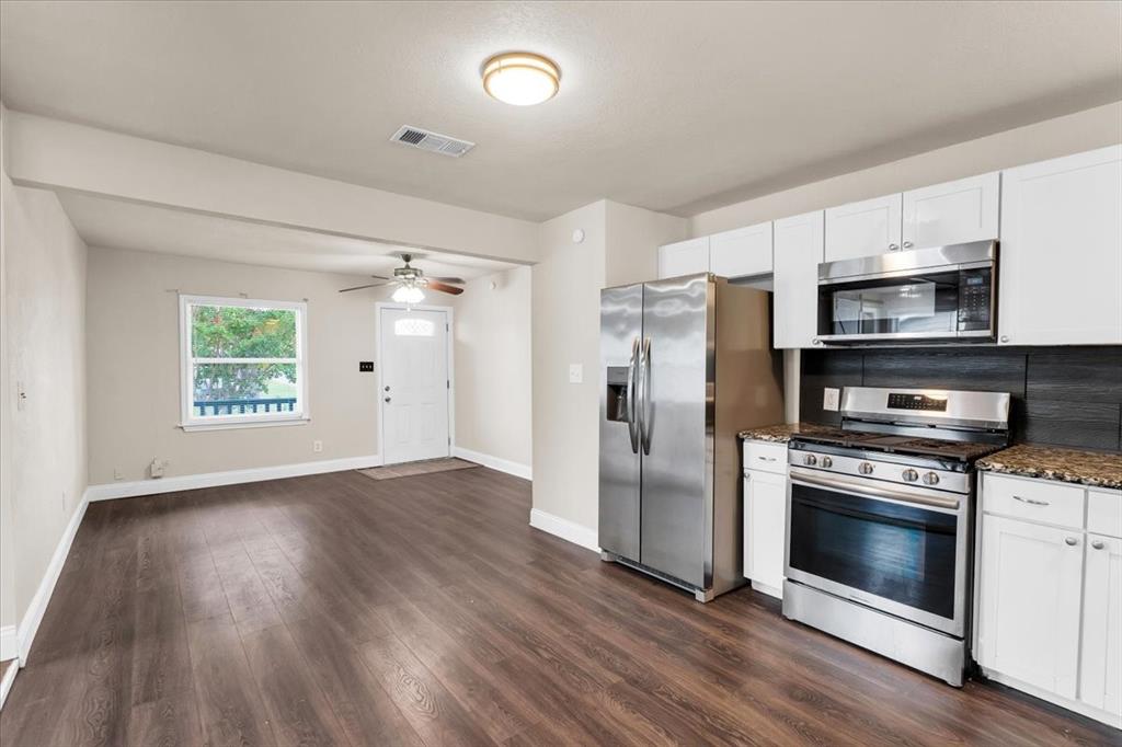 1309 Pine Street Bonham, TX 75418 - Photo 5 of 33 a kitchen with stainless steel appliances a stove microwave and a refrigerator