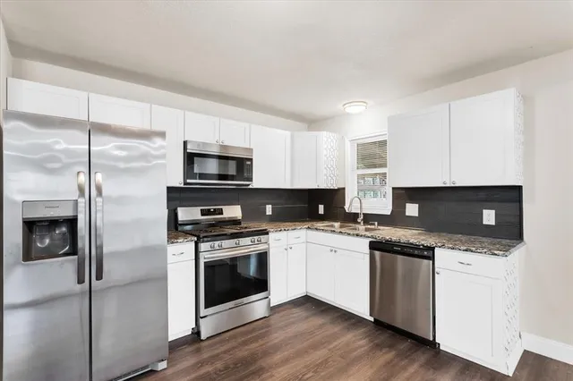 a kitchen with stainless steel appliances a stove a sink and a microwave